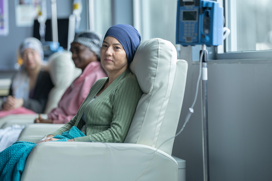 Several people sit in reclining chairs receiving IV treatment in a medical clinic.