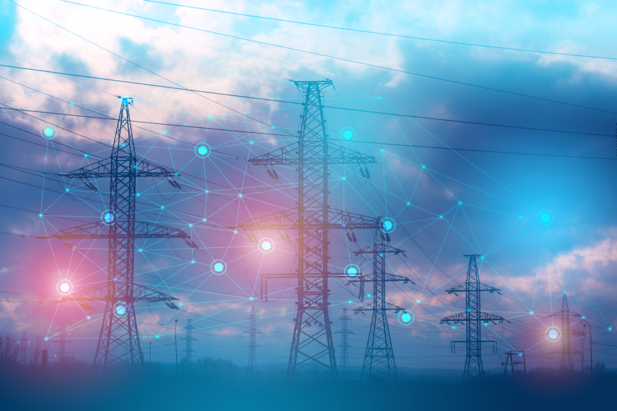 Transmission towers overlaid with a glowing digital network graphic against a cloudy sky.